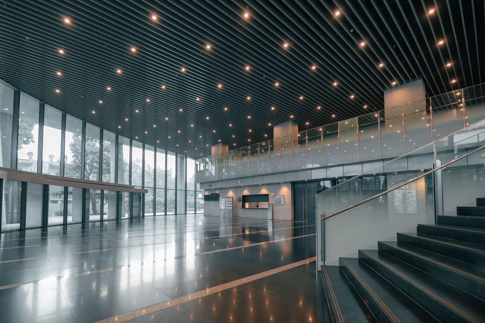 Átrio de um edifício empresarial com chão brilhante e escadaria